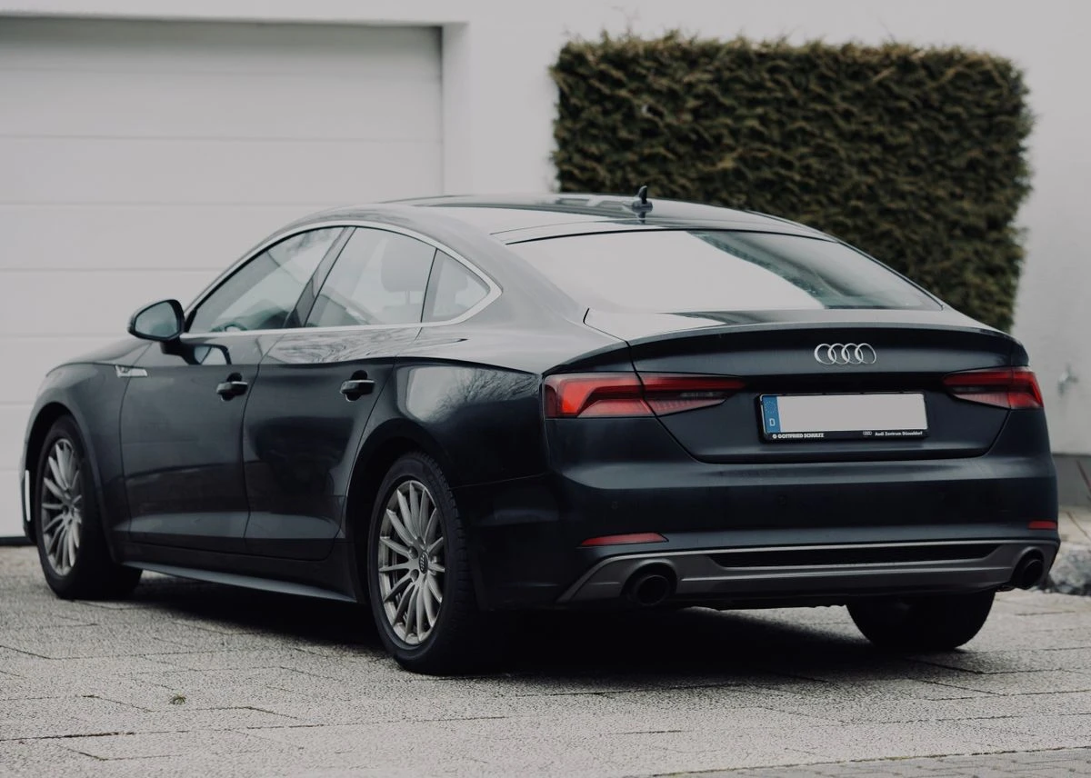 Illustrative black luxury sedan photographed outdoors