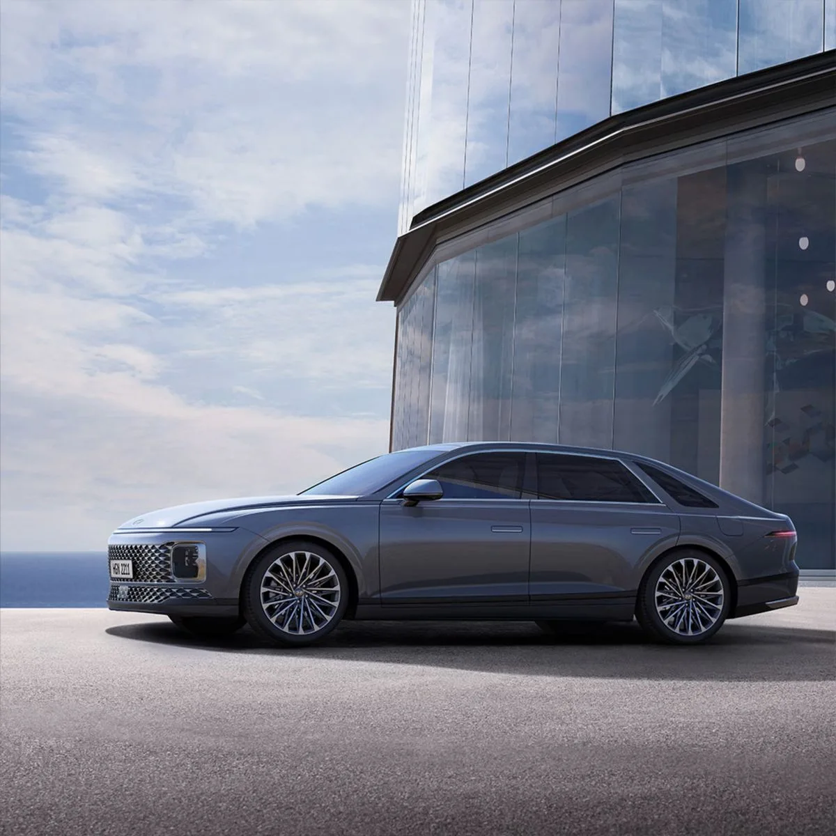 Illustrative executive sedan beside a modern building