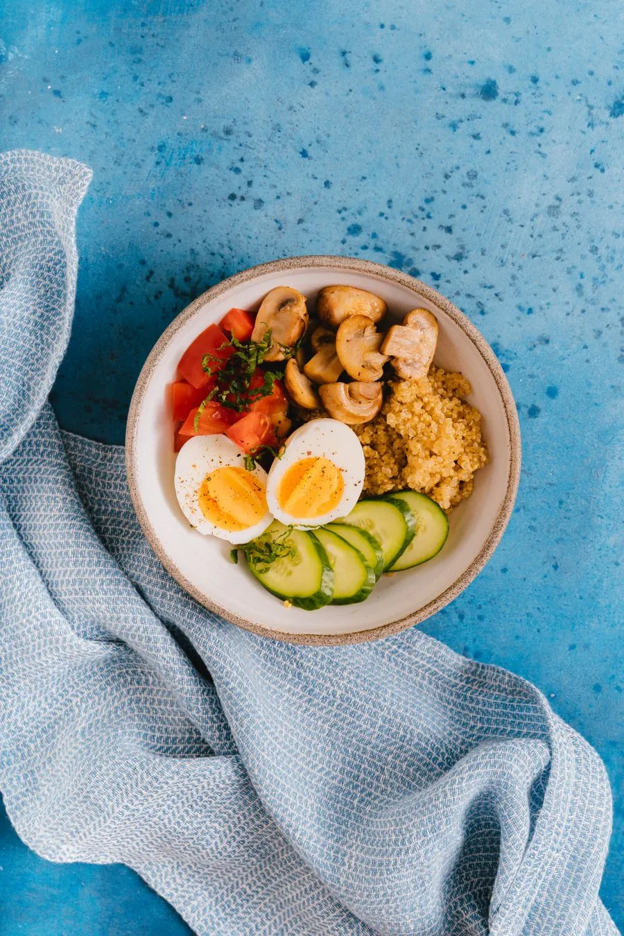 Colorful healthy bowl with rice, egg and fresh vegetables on a bright background