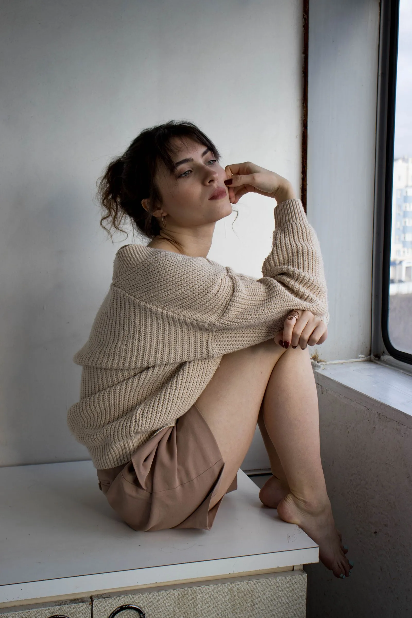 Elena Marsh, founder of Fieldspun, in a beige knit sweater beside a sunlit window