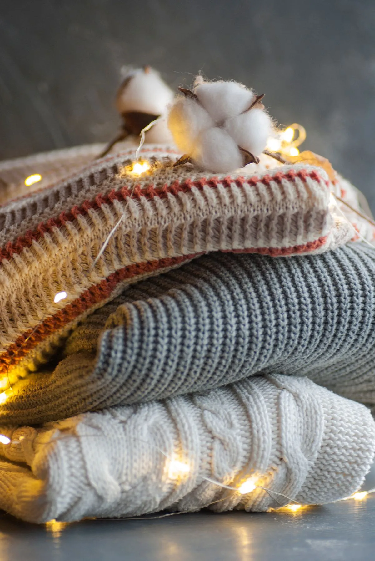 A soft cotton boll resting on a cream organic-cotton knit, fibers catching the light.