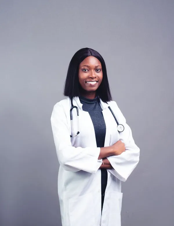 Dr. Maya Okafor, MD, Founder & Physician, smiling in a white coat with a stethoscope
