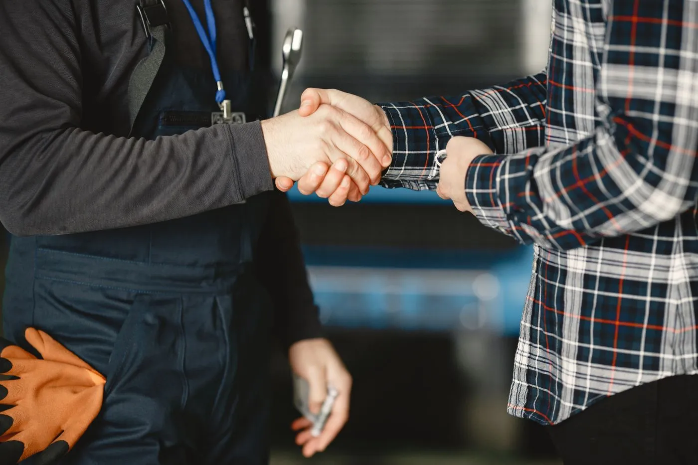 Homeowner in plaid shirt shaking hands with a Summit technician in work uniform